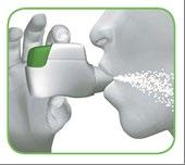 Mano che tiene un dispositivo spray nasale bianco e verde mentre viene spruzzato un getto di polvere bianca nel naso