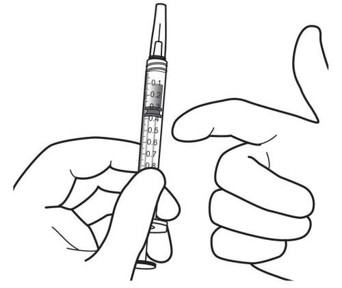 Mano che tiene una siringa graduata con ago, pronta per l