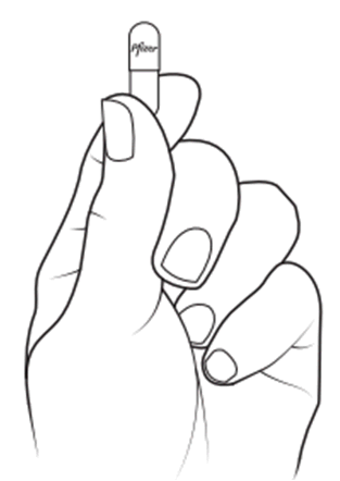 Mano che afferra una capsula farmaceutica bianca con la punta rivolta verso l