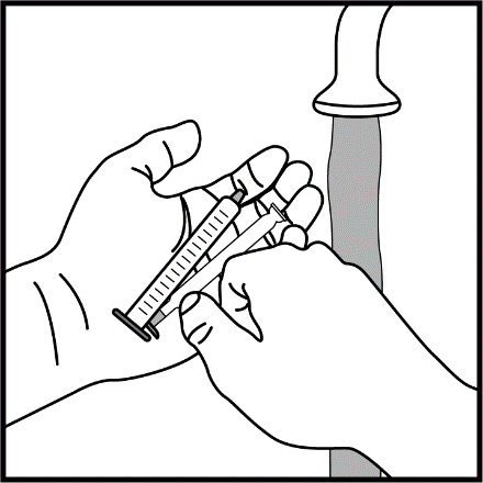 Mano che afferra una siringa pronta per l