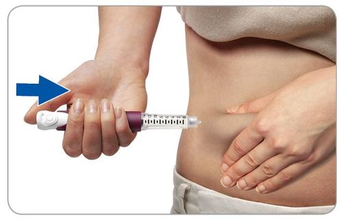 Mano che afferra una penna per iniezione con ago inserito nella pelle dell