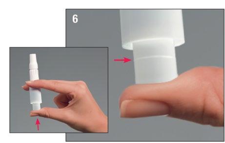 Mano che tiene un adattatore bianco e lo inserisce in un dispositivo penna per iniezione, freccia rossa indica la direzione