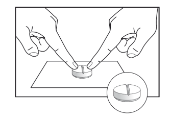Due mani che afferrano una compressa bianca e un ingrandimento mostra la compressa divisa a met&agrave;
