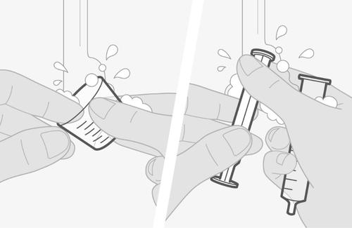 Mano che pulisce un ago di siringa con un batuffolo di cotone imbevuto di alcol, gocce di liquido visibili attorno