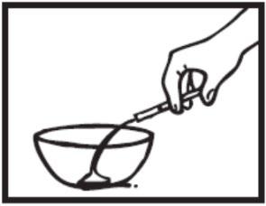 Mano che tiene una siringa sopra una ciotola con un liquido all