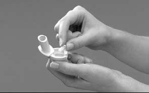 Mani che tengono e manipolano un inalatore bianco a forma di conchiglia con un boccaglio cilindrico esteso