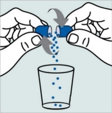 Capsula blu che si apre con palline che cadono in un bicchiere trasparente frecce indicano il movimento