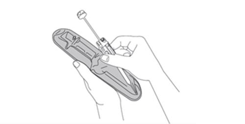 Mano che inserisce un dispositivo autoiniettante con ago trasparente nella parte superiore di un supporto curvo grigio