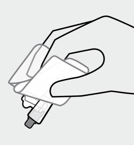 Mano che tiene un dispositivo autoiniettante con ago esposto e finestra di visualizzazione trasparente