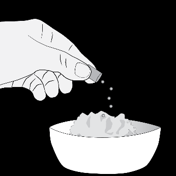 Mano che versa granuli bianchi da una capsula aperta in una ciotola contenente cubetti di ghiaccio