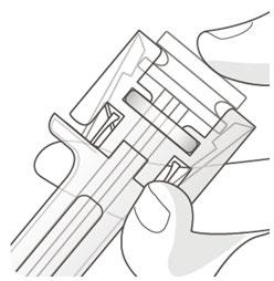 Dettaglio di un dispositivo di sicurezza per ago, con protezione trasparente e meccanismo di blocco visibile