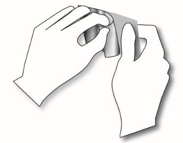 Mani con guanti che aprono un blister di farmaci contenente una compressa bianca o pallida