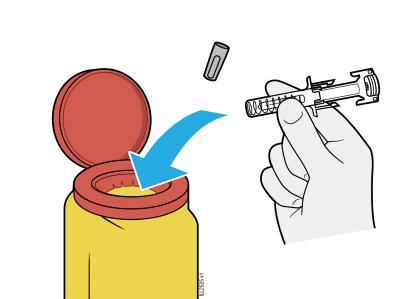 Fiala gialla aperta con tappo rosso e ago da iniezione tenuto in mano, freccia blu indica l