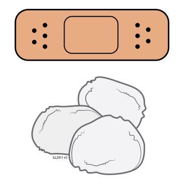 Cerotto adesivo marrone con fori neri sopra tre batuffoli di cotone bianco su sfondo bianco