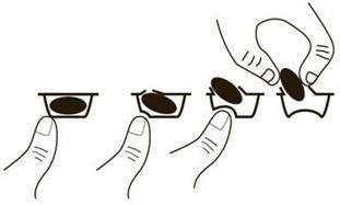 Mani che aprono un blister contenente due capsule ovali scure estraendole gradualmente dall