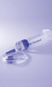 Siringa trasparente con stantuffo blu e ago collegato a un tubo flessibile trasparente su sfondo chiaro