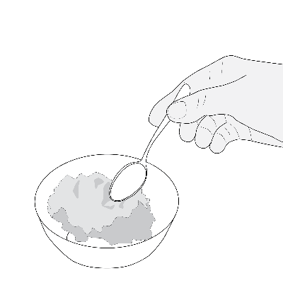 Mano che tiene un cucchiaino sopra una tazza contenente una sostanza grigia e granulosa