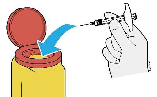Mano che tiene una siringa sopra un vasetto medicinale aperto di colore rosso e giallo con una freccia blu che indica la direzione
