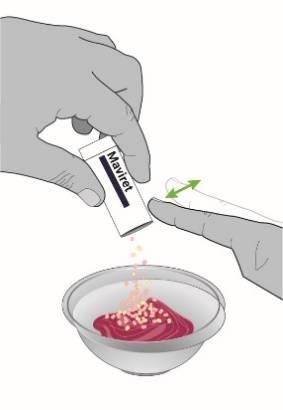Mano che versa il contenuto di una bustina Mavirret in una ciotola con liquido rossastro e schiuma bianca