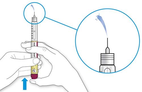 Siringa preriempita tenuta in mano con ago inserito, dettaglio ingrandito dell