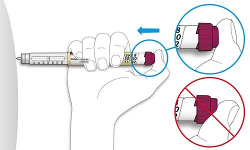 Penna iniettabile con ago trasparente, mano che ruota il dosatore e cerchi blu che indicano la direzione corretta e un divieto in rosso