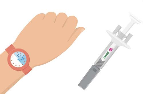 Braccio con orologio che mostra il tempo e siringa preraimpostata Insulair con ago per iniezione sottocutanea