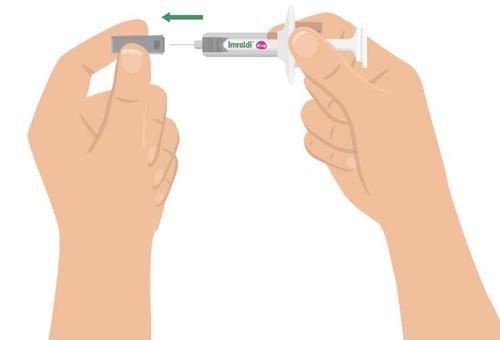 Mani che tengono una siringa pre-riempita Imraldi con ago protetto e un dispositivo di sicurezza grigio a fianco