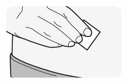 Mano che tiene una compressa bianca rettangolare sopra la pelle del braccio con un bendaggio grigio