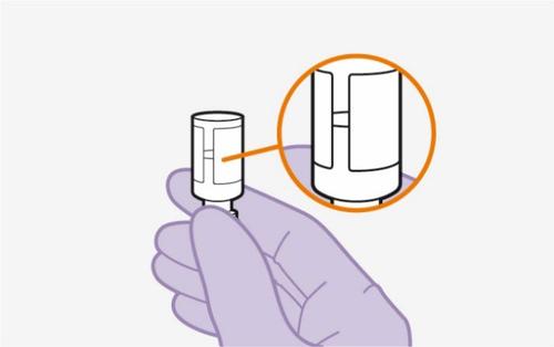 Mano con guanto viola che tiene un dispositivo cilindrico bianco con un ingrandimento circolare che mostra i dettagli del meccanismo
