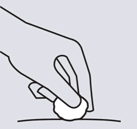 Mano che tiene un batuffolo di cotone bianco premuto sulla pelle con l