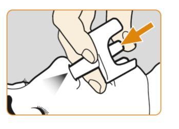 Mano che tiene un dispositivo autoiniettante bianco con freccia arancione indicante il punto di pressione sulla pelle