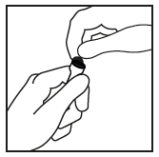 Due mani che stringono un piccolo oggetto rotondo e scuro probabilmente una capsula o compressa