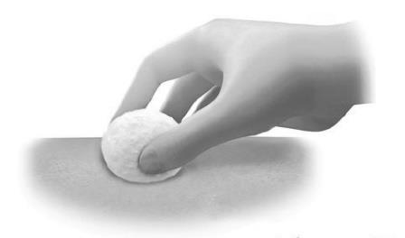 Mano che preme un batuffolo di cotone su una zona della pelle per disinfettare prima di un