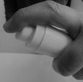 Mano che tiene un inalatore bianco a forma cilindrica con il pollice premuto sull