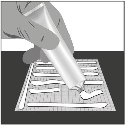 Mano che applica una crema da un tubetto su una superficie a griglia con linee bianche parallele