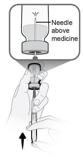 Mano che tiene una siringa con ago mentre aspira il farmaco da una fiala trasparente freccia nera indica direzione aspirazione