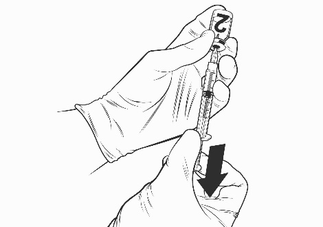 Mano con guanto che tiene una siringa con l