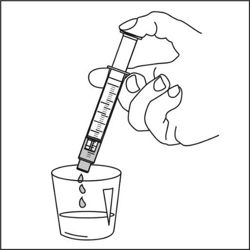 Mano che tiene una siringa sopra un contenitore trasparente da cui fuoriescono alcune gocce di liquido