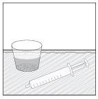 Bicchiere contenente liquido e siringa senza ago appoggiata su una superficie orizzontale