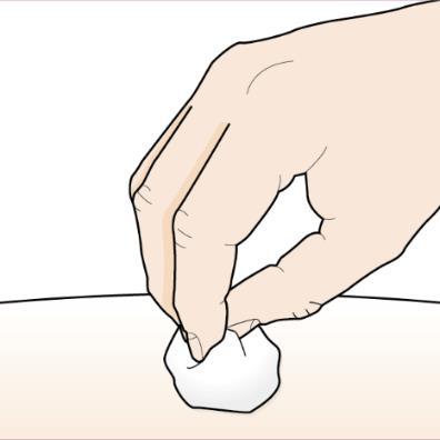 Mano che afferra un batuffolo di cotone bianco su una superficie cutanea chiara e liscia