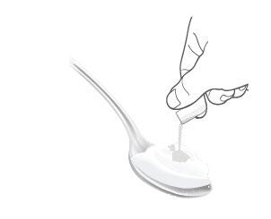 Cucchiaio contenente una sostanza bianca cremosa con una goccia che cade dal bordo