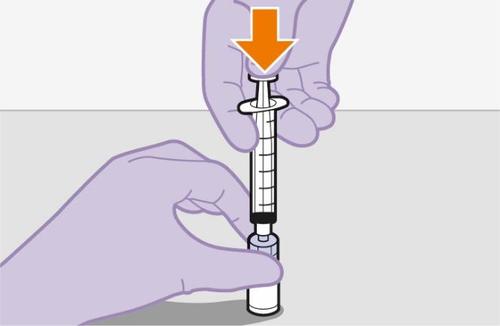 Mano con guanto viola che tiene una siringa trasparente con ago rivolto verso il basso e freccia arancione indicante la direzione