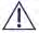 Segnale di avvertimento triangolare nero con punto esclamativo centrale su sfondo bianco