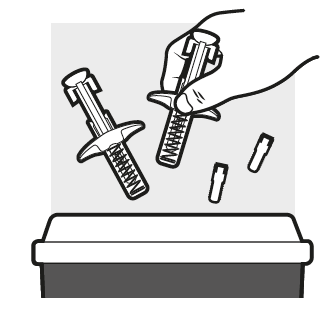 Mano che tiene una siringa preriempita e due aghi di diverse dimensioni sopra un contenitore per rifiuti speciali