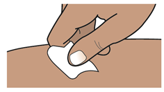 Mano che pulisce la pelle con un tampone di cotone bianco prima di un