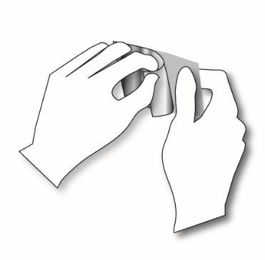 Mani con guanti che aprono una bustina sigillata di farmaco, strappando l