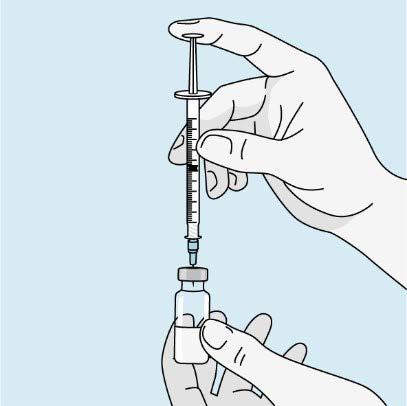 Mano che riempie una siringa da un flaconcino di medicinale trasparente con ago collegato