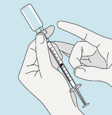 Mano che tiene una siringa piena collegata ad una fiala trasparente con ago metallico pronto per l