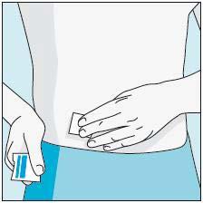 Mano che applica un cerotto adesivo bianco e blu sulla pelle del ginocchio destro coperto da jeans blu