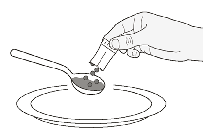 Mano che versa granuli da una bustina su un cucchiaio tenuto sopra un piatto circolare